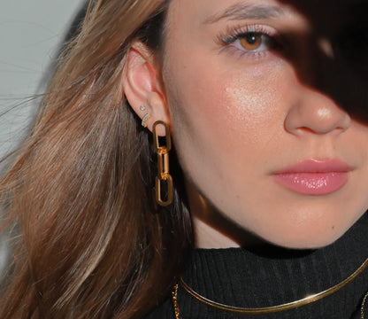 Model wearing paper clip style dangling earrings