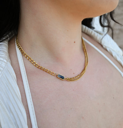 gold chain with black stone accent on model