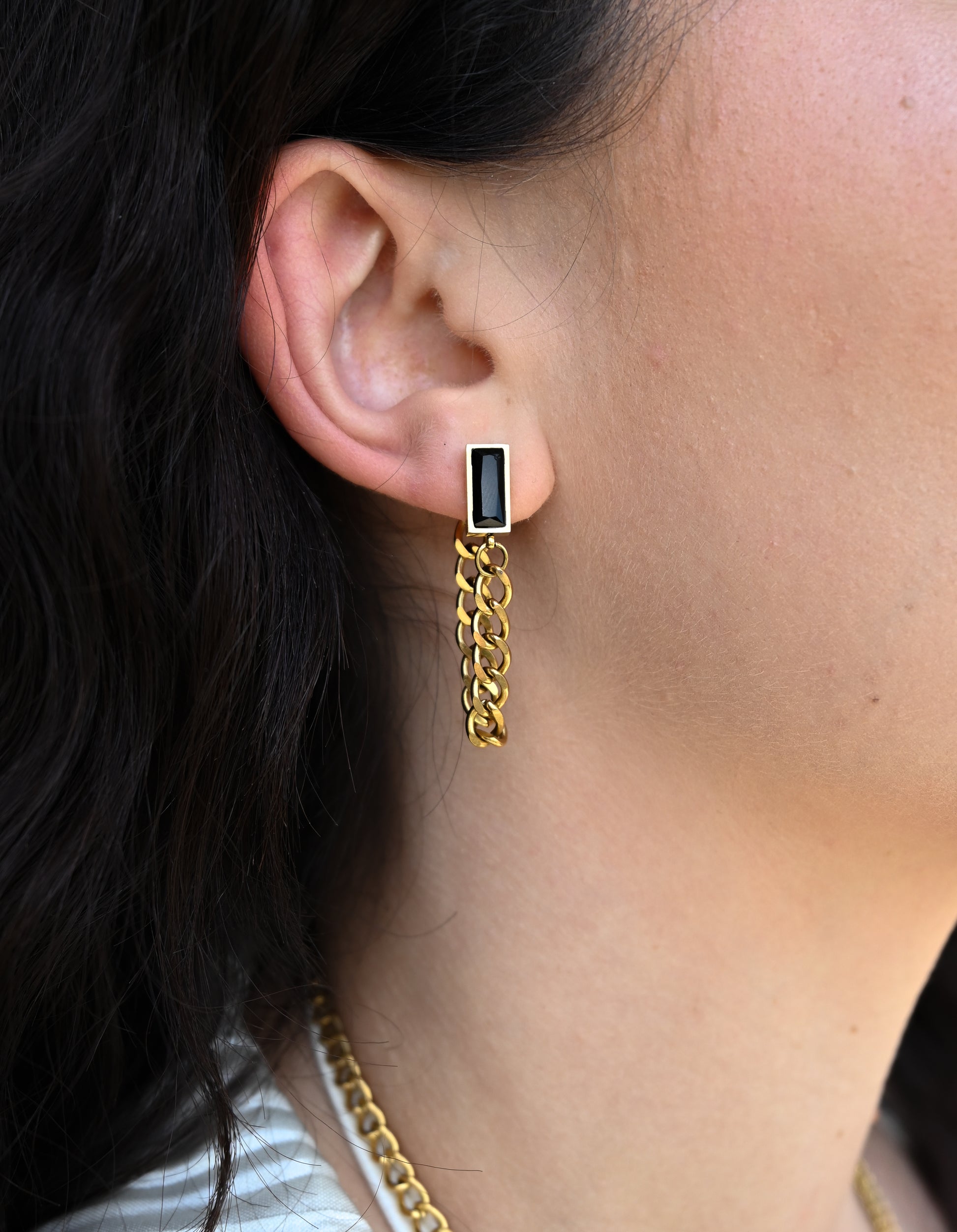 gold chain earrings with black stone accent  on model