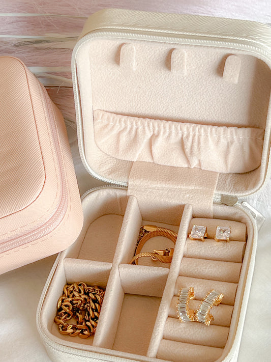 our travel jewelry case open showing it carrying different styles of jewelry in its compartments