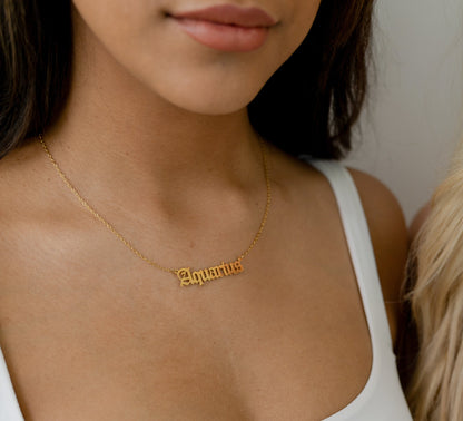 model wearing gold zodiac sign chain 